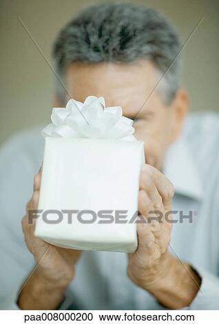 Man holding up gift View Large Photo Image Stock Image - Man holding up gift. Fotosearch