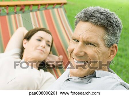 Stock Image - Mature couple lounging in hammock. Fotosearch
