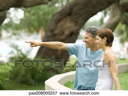 Mature couple, pointing toward distance, side view View Large Photo Image Stock Photo - Mature couple, pointing toward distance, side view. Fotosearch