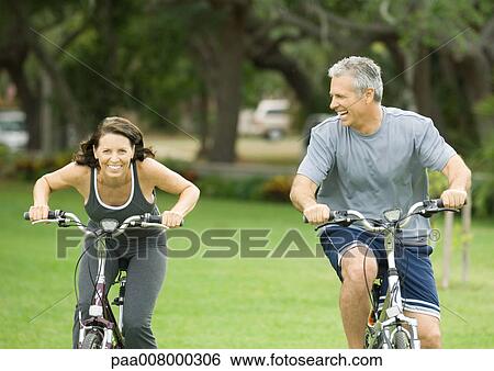 Mature couple riding bikes View Large Photo Image Stock Photograph - Mature couple riding bikes. Fotosearch