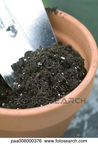 Stock Photograph - Pot full of soil and trowel. Fotosearch