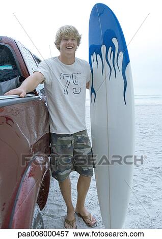 Surfer standing next to pick-up truck with surfboard View Large Photo Image Stock Photo - Surfer standing next to pick-up truck with surfboard. Fotosearch