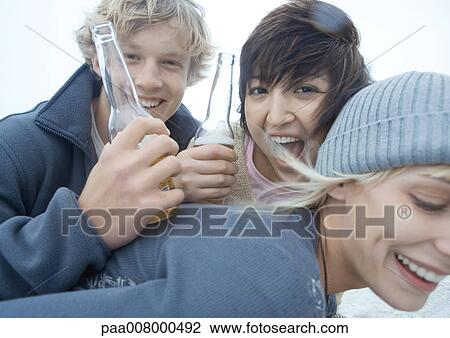 Three friends with beer bottles, smiling and laughing View Large Photo Image Stock Image - Three friends with beer bottles, smiling and laughing. Fotosearch