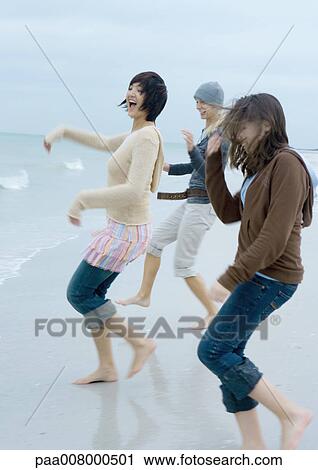 Three young women running toward surf View Large Photo Image Stock Image - Three young women running toward surf. Fotosearch