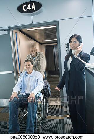 Traveler in wheelchair arriving at gate in airport View Large Photo Image Stock Image - Traveler in wheelchair arriving at gate in airport. Fotosearch