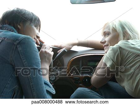 Two female friends sitting in car, leaning forward View Large Photo Image Stock Photo - Two female friends sitting in car, leaning forward. Fotosearch