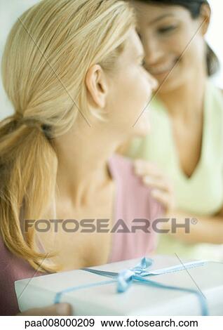 Stock Photo - Two female friends with gift. Fotosearch