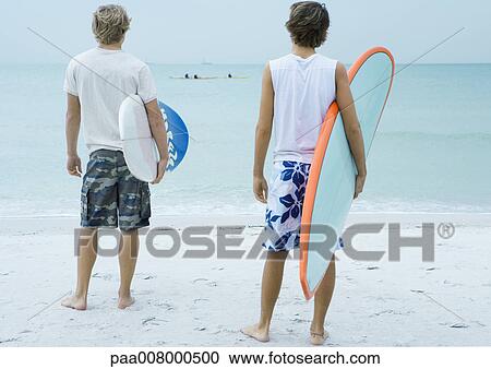 Two surfers looking toward ocean View Large Photo Image Stock Image - Two surfers looking toward ocean. Fotosearch