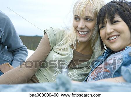Two young women reclining and smiling View Large Photo Image Stock Image - Two young women reclining and smiling. Fotosearch