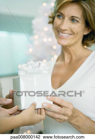 Woman being handed present from child View Large Photo Image Stock Image - Woman being handed present from child. Fotosearch