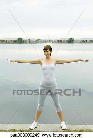 Stock Photo - Woman exercising, lakeside. Fotosearch