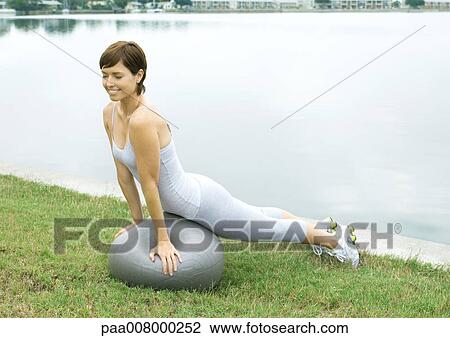 Woman exercising with fitness ball, next to lake View Large Photo Image Stock Image - Woman exercising with fitness ball, next to lake. Fotosearch