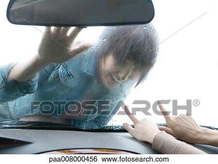 Woman lying on hood of car, looking through windshield View Large Photo Image Stock Photograph - Woman lying on hood of car, looking through windshield. Fotosearch