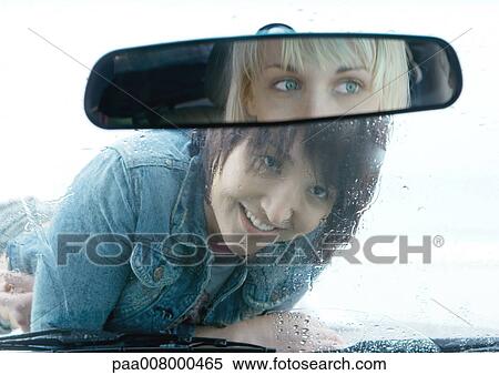Woman lying on hood of car, looking through windshield View Large Photo Image Stock Photography - Woman lying on hood of car, looking through windshield. Fotosearch