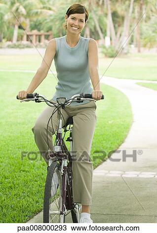 Woman on bike, smiling View Large Photo Image Stock Image - Woman on bike, smiling. Fotosearch