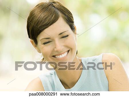 Stock Image - Woman smiling with eyes shut. Fotosearch