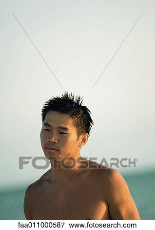 Stock Photo - Barechested man, sea in background. Fotosearch