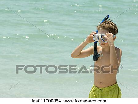 Boy adjusting snorkeling gear on beach View Large Photo Image Picture - Boy adjusting snorkeling gear on beach. Fotosearch