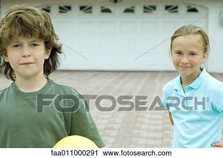 Boy and girl standing in front of driveway, smiling View Large Photo Image Stock Image - Boy and girl standing in front of driveway, smiling. Fotosearch