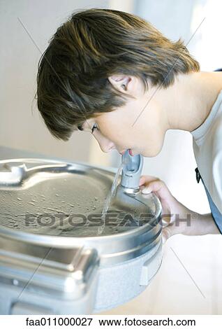 Boy drinking from water fountain View Large Photo Image Stock Photo - Boy drinking from water fountain. Fotosearch