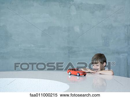 Boy looking at toy car View Large Photo Image Stock Photography - Boy looking at toy car. Fotosearch