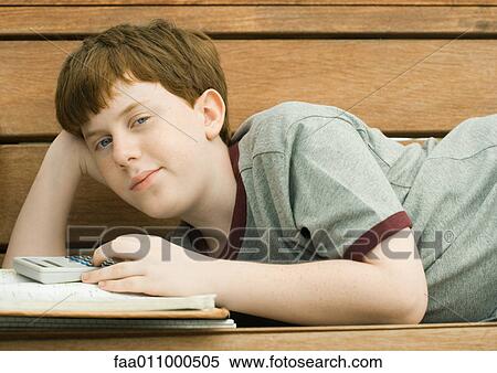 Boy lying on bench with homework View Large Photo Image Stock Photography - Boy lying on bench with homework. Fotosearch