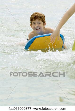 Boy on body board in sea View Large Photo Image Stock Photo - Boy on body board in sea. Fotosearch