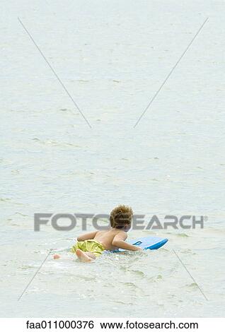 Boy on body board in sea View Large Photo Image Stock Photograph - Boy on body board in sea. Fotosearch
