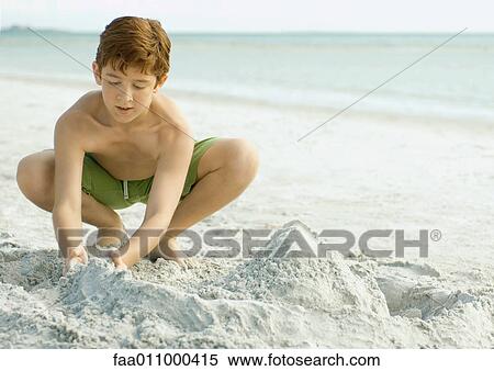 Boy playing in sand on beach View Large Photo Image Stock Photography - Boy playing in sand on beach. Fotosearch
