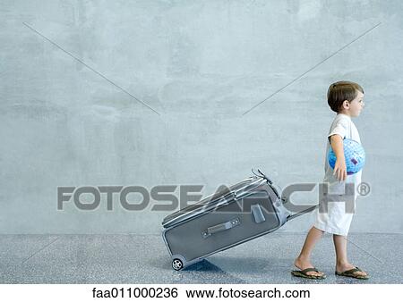 Boy pulling suitcase and carrying globe under arm View Large Photo Image Stock Photograph - Boy pulling suitcase and carrying globe under arm. Fotosearch