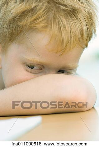 Stock Photograph - Boy resting head on arm. Fotosearch