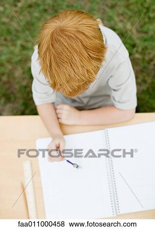 Stock Photo - Boy sitting with open notebook. Fotosearch