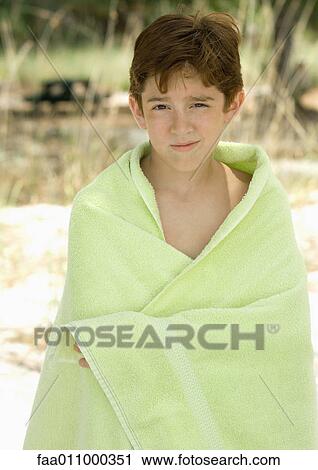 Boy standing wrapped in towel on beach View Large Photo Image Stock Image - Boy standing wrapped in towel on beach. Fotosearch