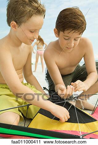Boys preparing kite on beach View Large Photo Image Stock Image - Boys preparing kite on beach. Fotosearch