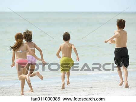 Stock Photography - Children running together on beach. Fotosearch