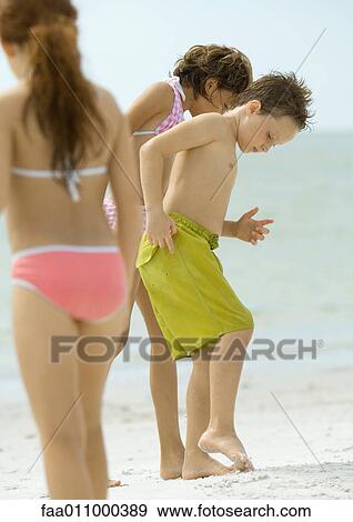 Children standing on beach, looking down at sand View Large Photo Image Stock Photo - Children standing on beach, looking down at sand. Fotosearch