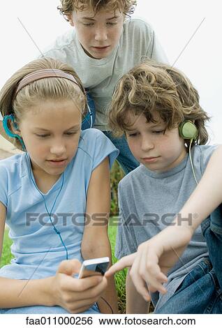 Children wearing earphones and lookng at mp3 player View Large Photo Image Stock Photograph - Children wearing earphones and lookng at mp3 player. Fotosearch