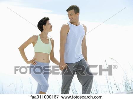 Stock Photo - Couple walking in exercise clothes. Fotosearch