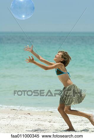 Girl catching beach ball on beach View Large Photo Image Stock Photography - Girl catching beach ball on beach. Fotosearch