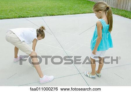 Girl drawing hopscotch game on driveway while second girl waits View Large Photo Image Stock Photograph - Girl drawing hopscotch game on driveway while second girl waits. Fotosearch