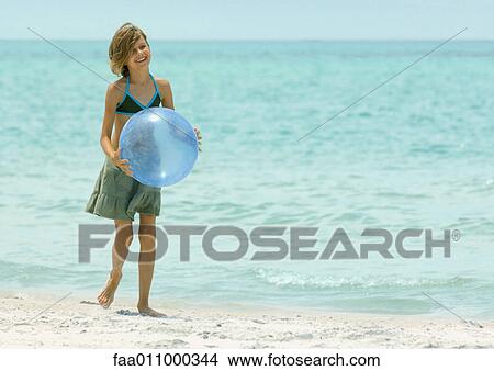 Girl holding beach ball on beach View Large Photo Image Picture - Girl holding beach ball on beach. Fotosearch