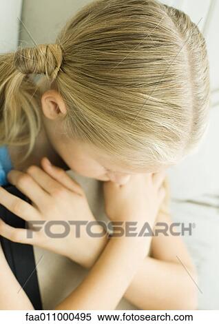 Girl holding book in front of chest, arms crossed and head down View Large Photo Image Stock Photography - Girl holding book in front of chest, arms crossed and head down. Fotosearch