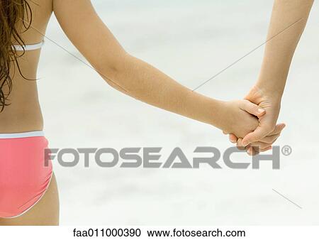 Girl holding hands with friend on beach, close-up View Large Photo Image Stock Image - Girl holding hands with friend on beach, close-up. Fotosearch