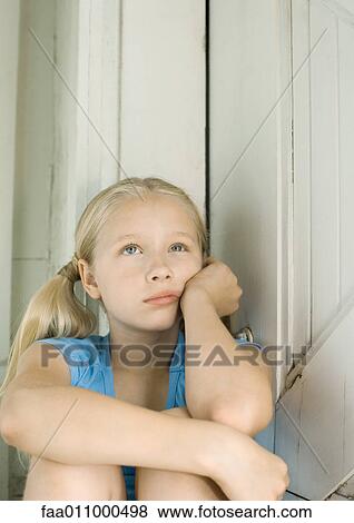 Girl holding head, looking up View Large Photo Image Stock Photo - Girl holding head, looking up. Fotosearch