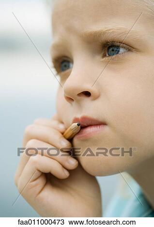 Girl holding pencil next to mouth View Large Photo Image Stock Image - Girl holding pencil next to mouth. Fotosearch