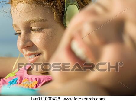 Stock Photo - Girl in bathing suit listening to earphones. Fotosearch