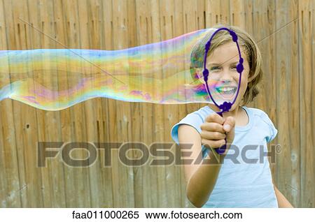 Stock Photography - Girl making bubble with bubble wand. Fotosearch