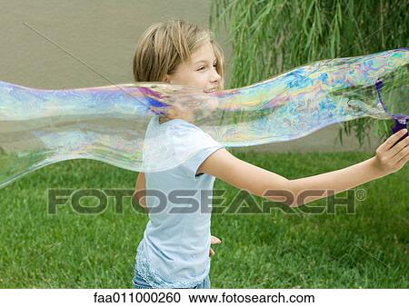 Girl making long bubble with bubble wand View Large Photo Image Stock Image - Girl making long bubble with bubble wand. Fotosearch