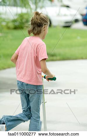Girl on push scooter View Large Photo Image Stock Photo - Girl on push scooter. Fotosearch