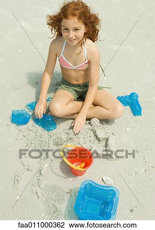 Girl playing in sand on beach View Large Photo Image Stock Image - Girl playing in sand on beach. Fotosearch